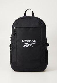 Čierny batoh s logom Reebok, vyrobený z odolného materiálu, s uzáverom na zips, prednou kapsou, sieťovými bočnými vreckami a nastaviteľnými popruhmi.