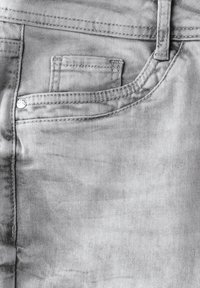 Grijze denim stofdetail met een klein zakje en contrasterende stiksels. Glad textuur met een lichte glans, geen zichtbare patronen of ontwerpen.