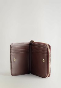 Portefeuille en cuir brun avec fermeture éclair, comportant plusieurs emplacements pour cartes et une poche à bouton-pression. Texture lisse et couture soignée.