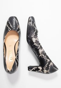 Černobílé hadí vzorované lodičky s špičatou špičkou, hladkým povrchem a lesklým finišem, vybavené nízkým blokovým podpatkem.