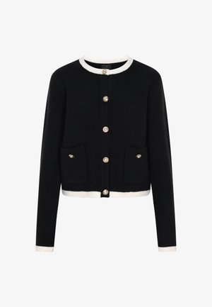 Black knitted cardigan with a round neckline, cream trim, gold-tone buttons, and two front pockets. Features a cropped design.