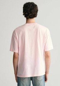 Korte mouwen, ronde hals t-shirt van zacht roze katoen. Heeft een ontspannen pasvorm met een rechte zoom en gestikte details op de mouwen en hals.