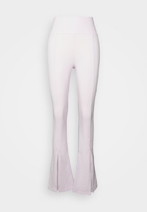 Kerged roosad püksid kõrge vöökoha ja sujuva tekstuuriga, alumise osa lõhega. Valmistatud venivast ja kehaümberkujundavast kangast.