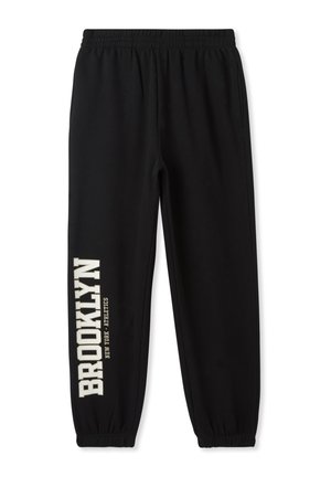 Joggers neri in cotone con vita e polsini elastici. "BROOKLYN" stampato in lettere crema in grassetto lungo la gamba sinistra. Fit semplice e rilassato.