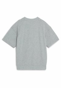 T-shirt oversize grigio in cotone, maniche corte, scollatura rotonda e texture morbida; minimo dettaglio di cucitura lungo il colletto e l'orlo.