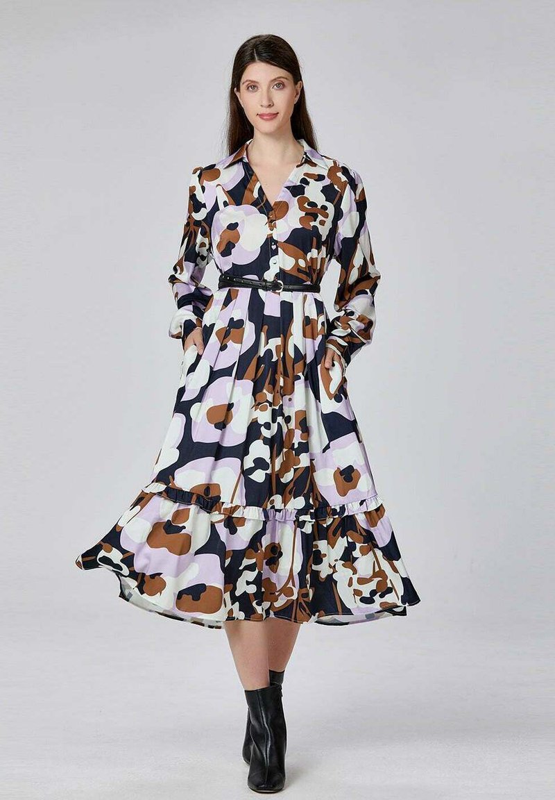 Robe longue à motifs floraux avec un design à boutons, couleurs noire, blanche, brune et violette, avec un ourlet volanté et des poches latérales.