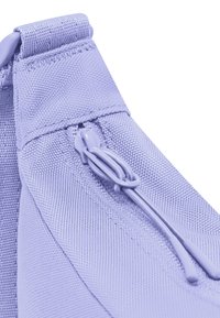 Borsa in tessuto viola chiaro con chiusura a zip liscia, superficie texture e cuciture resistenti ai bordi con un anello per appenderla.