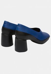 Chaussures en cuir bleu avec un bout arrondi et un design à coupe basse, dotées de talons en bloc noirs épais et d'une texture lisse.