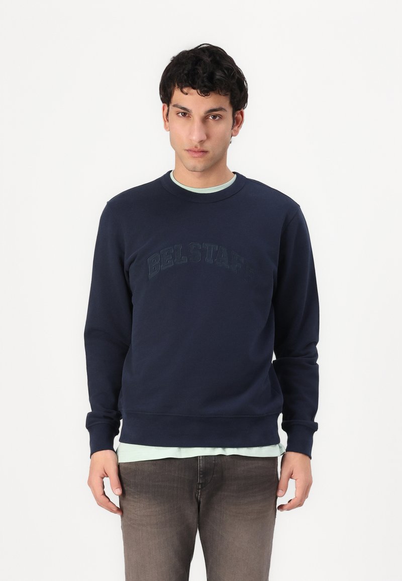Felpa blu navy con collo a giro, caratterizzata da un logo "BELSTAFF" tono su tono sul petto. Tessuto morbido e polsini a costine per un comfort ottimale.