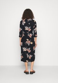 Midi šaty s květinovým potiskem v černé barvě, se třičtvrtinovými rukávy, staženým pasem a volným siluetou. Obsahují růžové a žluté květiny.