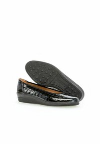 Zwarte gepatineerde leren instappers met een gestructureerd oppervlak en een lage, gevoerde wig hiel. De rubberen buitenzool heeft een stippenpatroon voor grip.