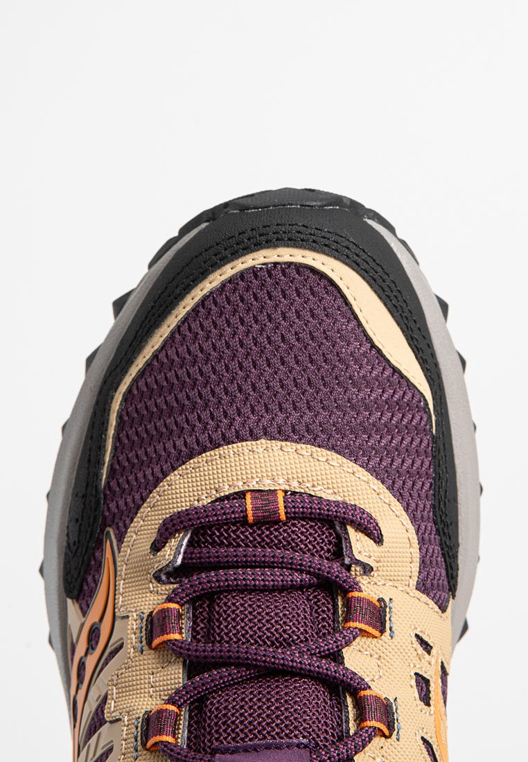 Scarpa da trail running con tomaia in rete viola, punta rinforzata nera, dettagli beige e sistema di lacci testurizzati per una vestibilità sicura.