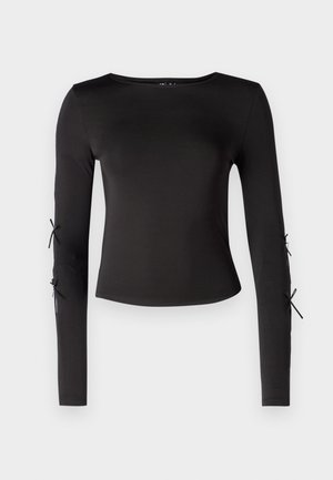 Camisola preta de manga longa com um decote redondo. Apresenta laços ajustáveis nas mangas, confecionada em um tecido liso e elástico.