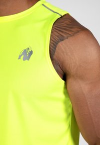 Neon gele mouwloze sporttop met een grijs gorilla-logo op de borst en reflecterende accenten op de schoudernaden. Zachte, rekbare stof.