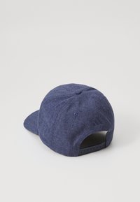 Blåt stoff baseballcaps med flat brem, teksturert materiale, justerbar snapback-lukking og brodert logo bak.
