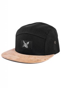 Gorra negra con visera de ante color beige, que presenta un parche negro con un diseño gráfico en blanco. La forma es estructurada con una visera plana.
