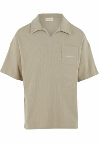 Beige kortermet polo-skjorte i teksturert stoff, med V-hals og en lomme på venstre bryst med subtil brodert detalj.