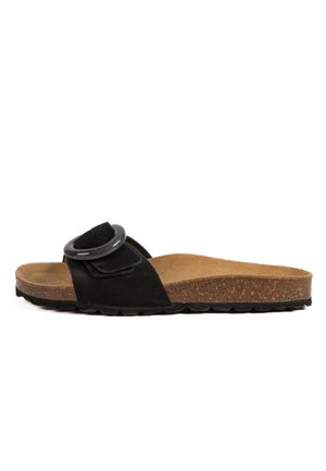 Sandale à glissière en suede noir avec une boucle circulaire noire, semelle en liège et semelle en caoutchouc texturé. Design plat, style ouvert à l'avant.
