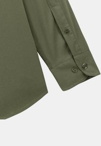 Chemise olive vert à manches longues avec des poignets à boutons, en tissu lisse. Elle présente un ourlet arrondi et comprend deux boutons sur chaque poignet.