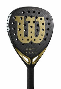 Wilson paddelracket med en svart och guld design, med en texturerad yta, stora perforeringar och ett grepphandtag. Modell: DEFY.