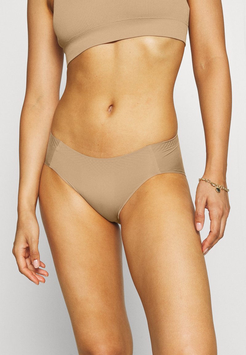 Bežna bikini spodnja del s gladko teksturo in zmerno pokritostjo. Ima brezšivne strane in preprost dizajn, prilagojen za udobje.