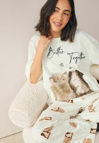 Hellgrünes Schlafanzugoberteil mit zwei illustrierten Meerschweinchen und dem Text "Besser zusammen". Passend dazu cremefarbene Schlafanzughosen mit braunen Meerschweinchen-Mustern.