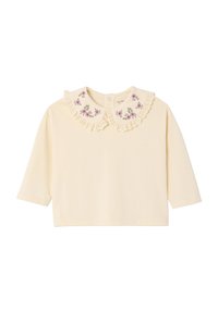 Cream long-sleeve top featuring a lace-trimmed, embroidered collar with floral patterns. Soft fabric and rounded hem for a relaxed fit.