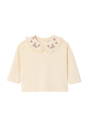 Cremfarbene Bluse mit langen Ärmeln, die einen mit Spitze verzierten, bestickten Kragen mit floralen Mustern aufweist. Weicher Stoff und abgerundeter Saum sorgen für eine lässige Passform.