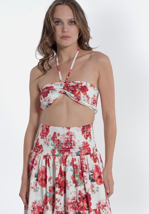 Kwiatowy zestaw składający się z dwóch części, z topem na halterze z twists oraz gumową spódnicą w talii. Materiał zdobią duże czerwone i różowe kwiaty na białym tle.