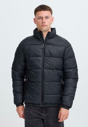 Zwarte pufferjack met een hoge kraag, een rits aan de voorkant en gestikte panelen. Beschikt over zijzakken en elastische manchetten voor een snug fit.