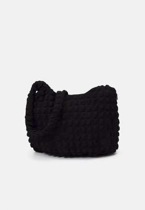 Sort struktureret skuldertaske med en rynket strop og blødt, polstret stof i en afrundet rektangulær form på en ensfarvet baggrund.