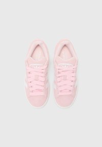 Ροζ σουέτ αθλητικά παπούτσια με άσπρες ρίγες, στρογγυλή μύτη και μαλακή γλώσσα. Διαθέτουν επίπεδα ροζ κορδόνια και υφασμάτινη ελαστική σόλα.