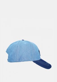 Casquette en denim avec une couronne bleu clair et une visière bleu foncé. Forme structurée avec surpiqûres contrastantes et une sangle réglable à l'arrière.