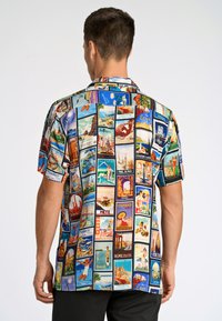 Korte mouwen shirt met een kleurrijke collage van vintage reiskaarten. Het materiaal is lichtgewicht met een gladde textuur.