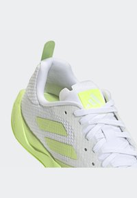 Weißer Sportschuh mit Obermaterial aus Mesh, neongrünen Akzenten und Drei-Streifen-Branding. Verfügt über einen gepolsterten Schaft und Schnürverschluss.