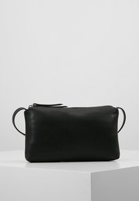Borsa in pelle nera con superficie liscia e texture, forma rettangolare, chiusura con zip e due manici laterali per una facile portabilità.