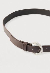 Cinto de couro castanho com acabamento liso, apresentando uma fivela metálica prateada e costuras visíveis ao longo das bordas.