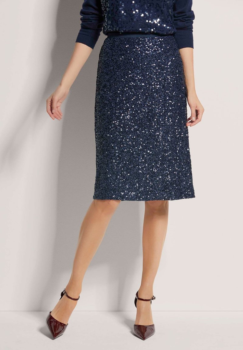 Navy paillettenrok met een aansluitend ontwerp, knielengte, textuur oppervlak, gecombineerd met puntige, glanzende bordeauxrode hakken.