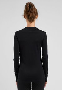 Black long-sleeve top made of soft, stretchy material, featuring a round neckline and fitted design, with slim sleeves and no visible patterns.