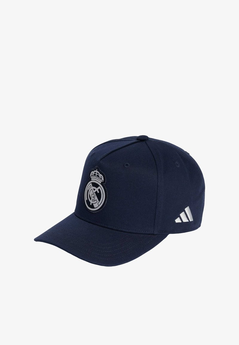 Casquette de baseball marine en tissu avec une visière incurvée. Présente un logo Real Madrid argenté et trois rayures blanches sur le côté.
