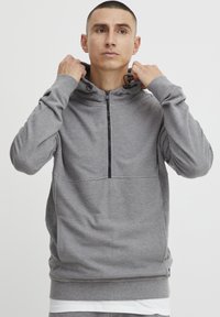 Grijze hooded sweatshirt met een halve rits, gestructureerde stof, kangoeroezak en trekkoorden in de capuchon. Eenvoudige en functionele stijl.