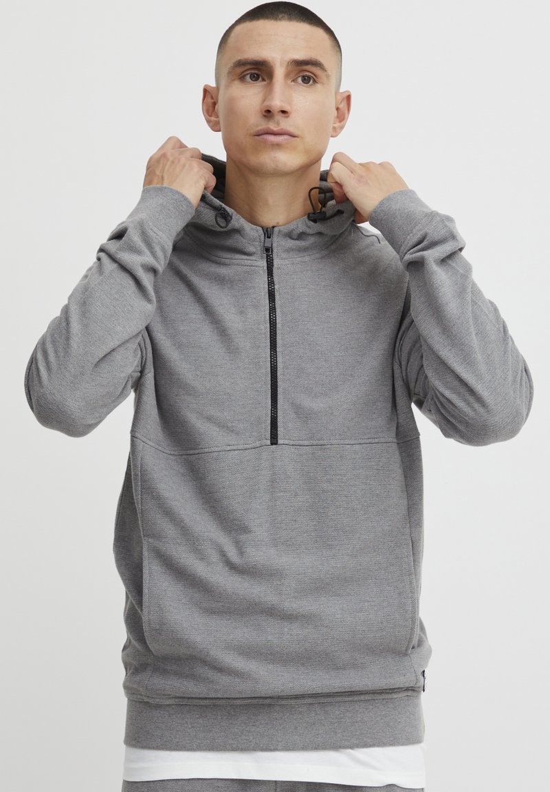 Grijze hooded sweatshirt met een halve rits, gestructureerde stof, kangoeroezak en trekkoorden in de capuchon. Eenvoudige en functionele stijl.