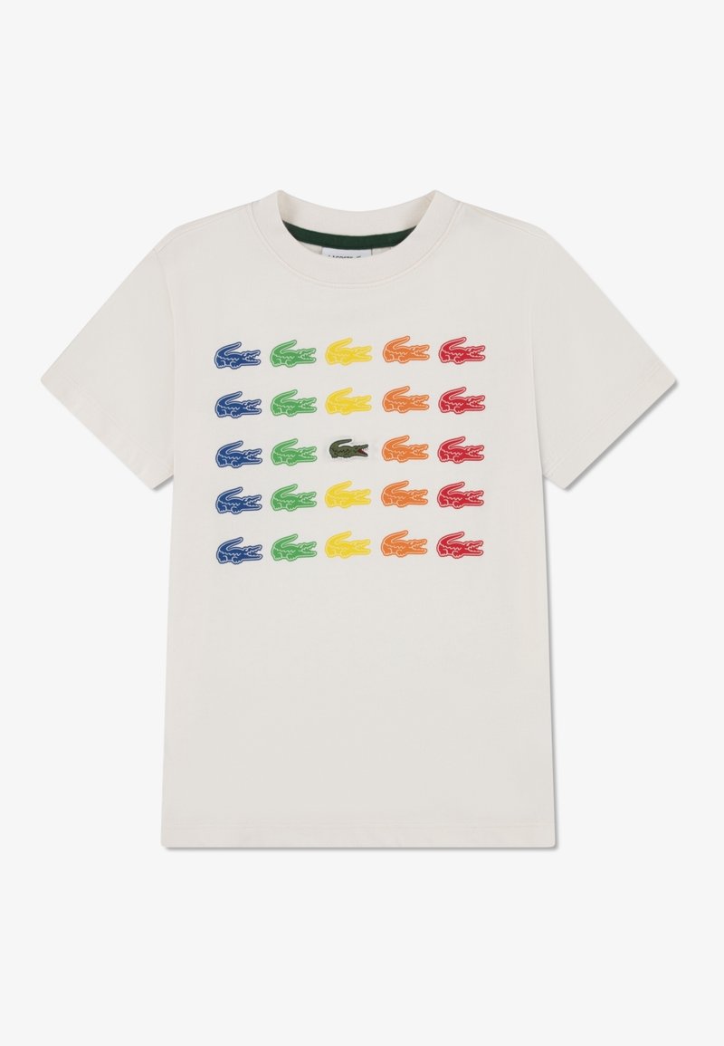 Camiseta blanca de manga corta con cinco filas de logotipos de cocodrilo bordados en colores azul, verde, amarillo, naranja, rojo y un centro en verde oscuro.