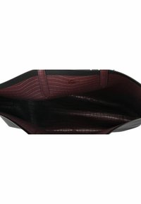 Material interior en burdeos con patrón de cocodrilo de un bolso tote negro, con forma estructurada y dos asas laterales, sin herrajes visibles.