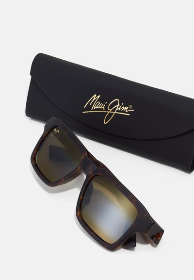 Brown tortoiseshell sunglasses with dark gradient lenses. Includes a black case featuring a gold logo. Angular design, smooth texture.