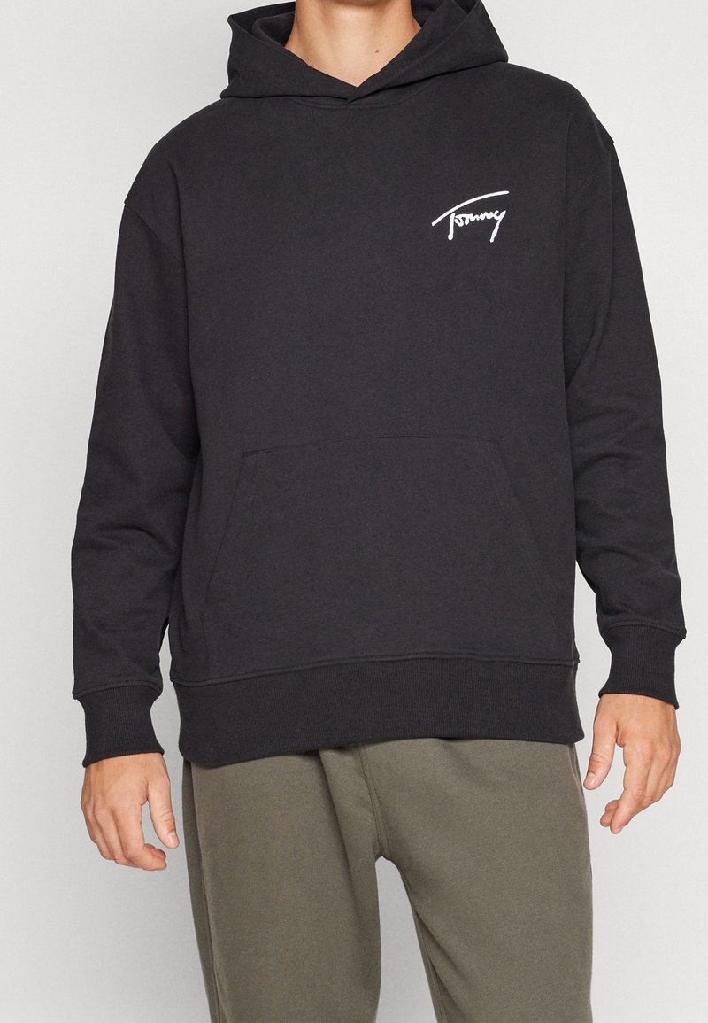 Felpa nera in misto cotone con tasca frontale, polsini e orlo a costine. Presenta un logo bianco sulla parte sinistra del petto.