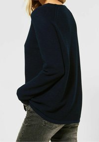 Mörkblå ribbad tröja med långa ärmar och rundad halsringning, med en avslappnad passform och texturerad tyg för ökad djup.