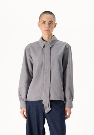 Chemise grise à manches longues avec un col pointu et un détail de cravate à l'avant, offrant une coupe décontractée et en matériau coton doux.