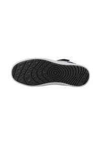 Suela de zapato de goma negra con patrones de tracción circulares y ovalados; acento de media suela blanca; textura suave; logo en el lateral.