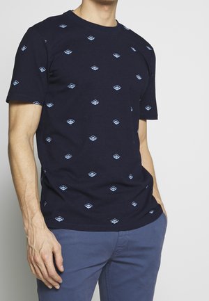T-shirt en coton bleu marine avec des motifs losanges bleu clair. Col rond, manches courtes et coupe décontractée.